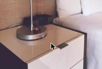 Clean hotel bed and nightstand - check the mattress seams and headboard for bed bugs when you arrive
